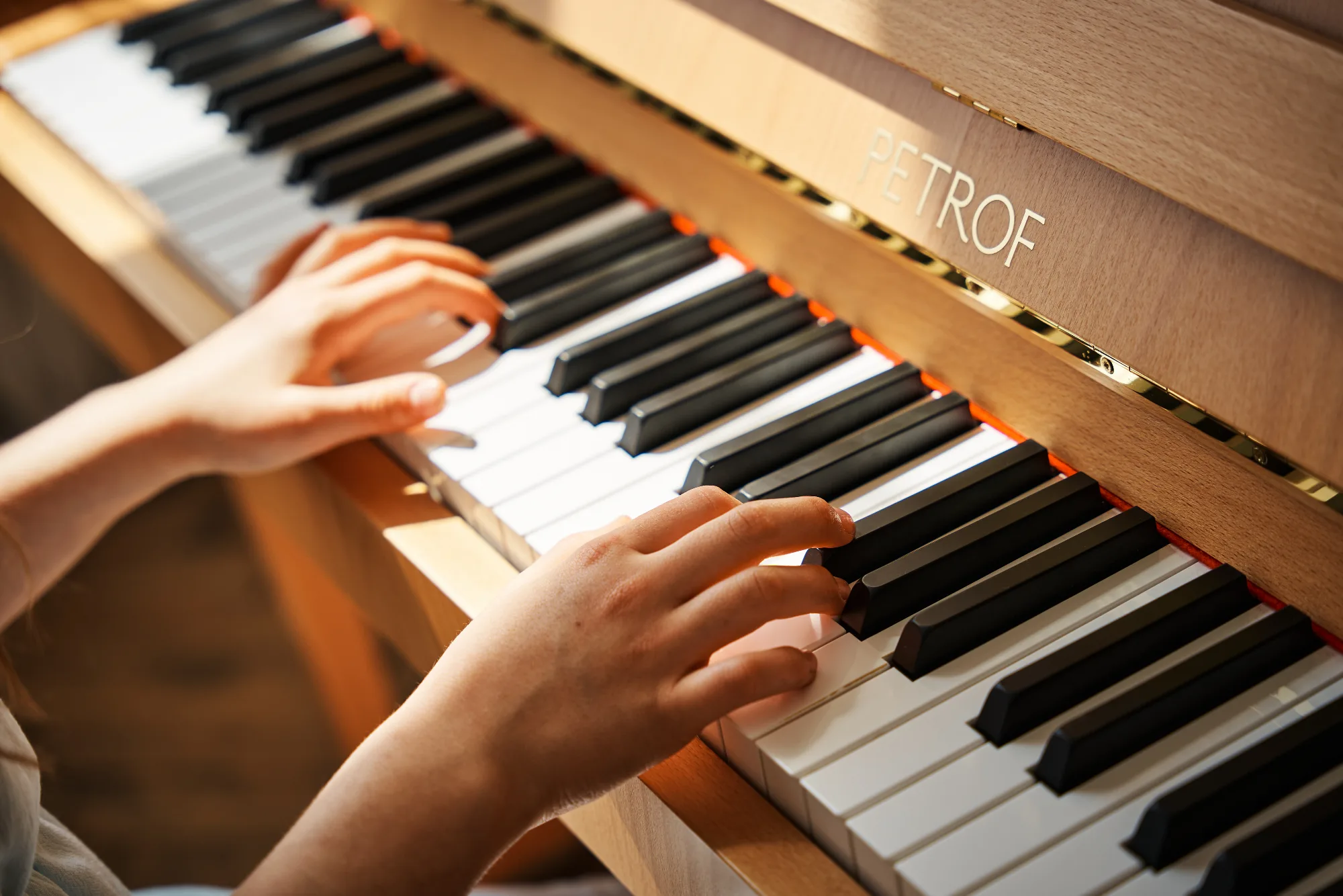 Mani su pianoforte verticale Petrof in showroom