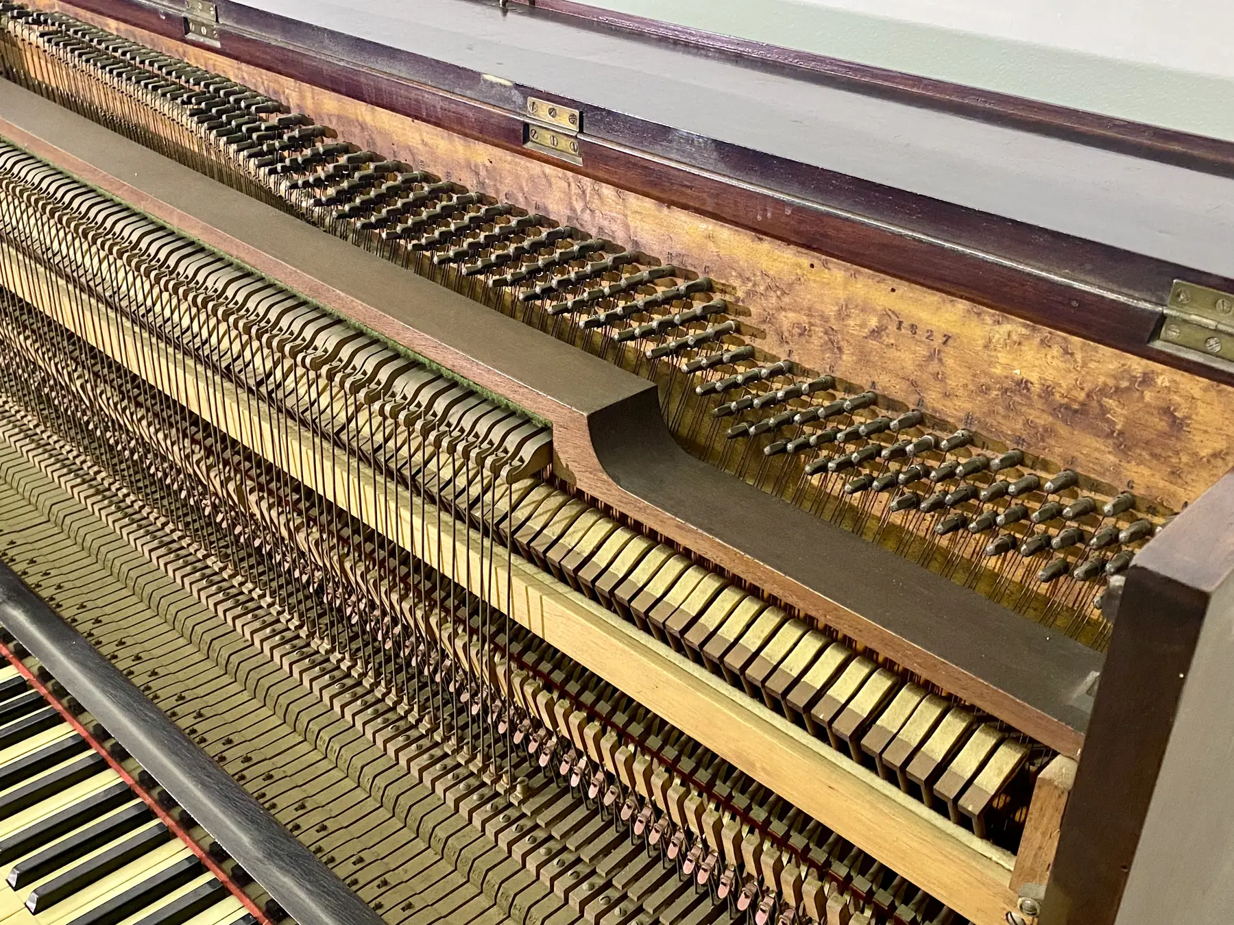 Interno di un pianoforte Aymonino con la matricola 1827 impressa e le corde dritte su telaio ligneo
